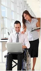 Photo of man in wheelchair and woman with laptops